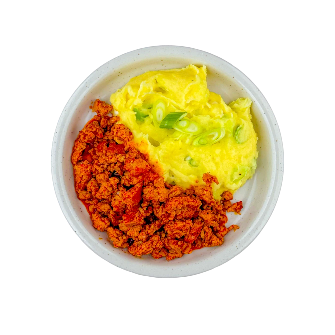 Angebratenes Schweinefleisch mit Kartoffelpüree und Frühlingszwiebeln